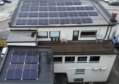 Bildet viser to sett med ferdigmonterte solcellepanel på et bygg i Vestfold